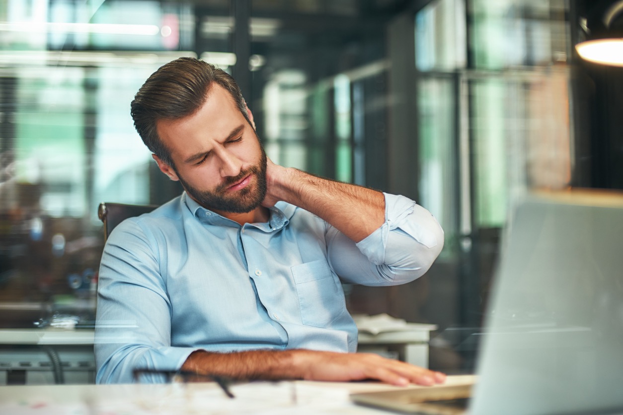 Man met nekklachten achter computer